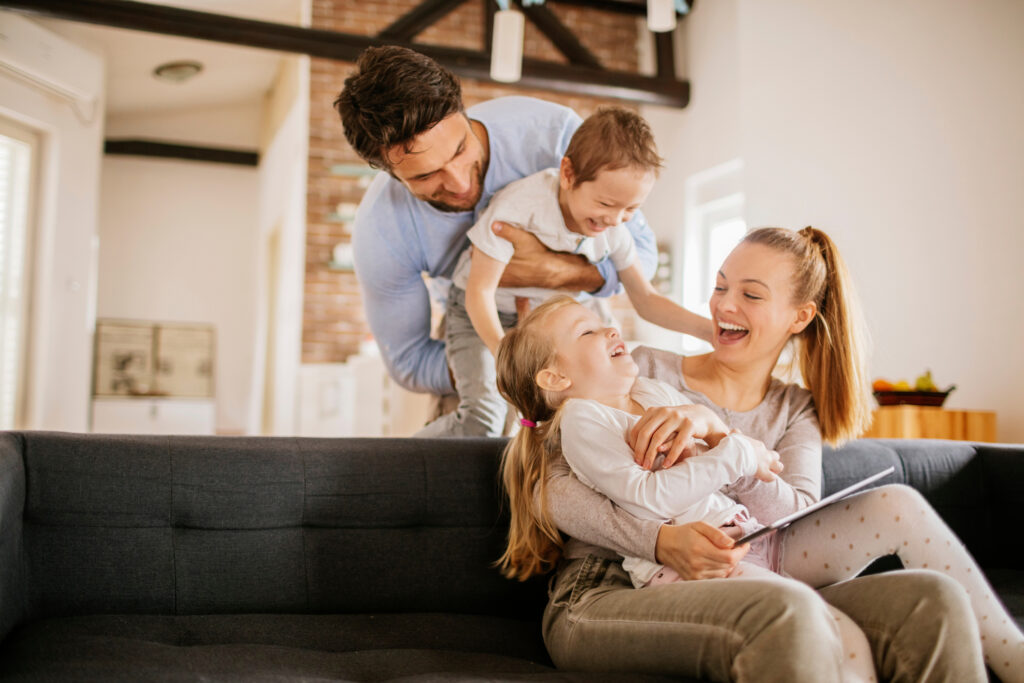 A family of four smiles and enjoys time together.