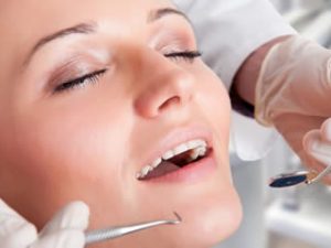 A woman appears to be in a carefree state during her dentist appointment, as though she is under conscious sedation.