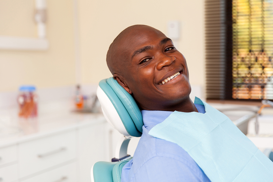 A man smiles in a dentist's chair as though he is free of dental anxiety.